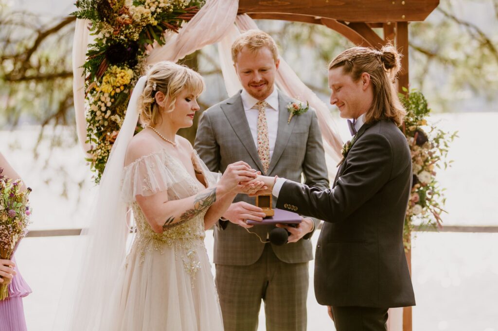 bride and groom exchanging rings during their wedding ceremony 