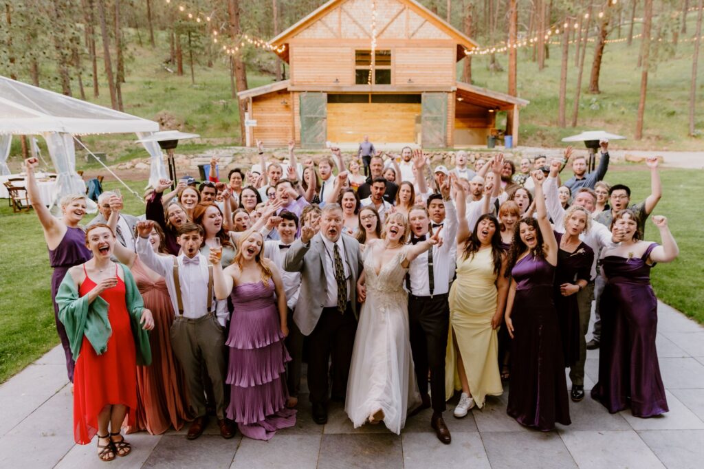 Joyful group photo of wedding guests celebrating outdoors at a Spokane wedding